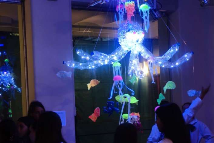 Niños mirando pieza en la exposición "Iluminando el Reciclaje"