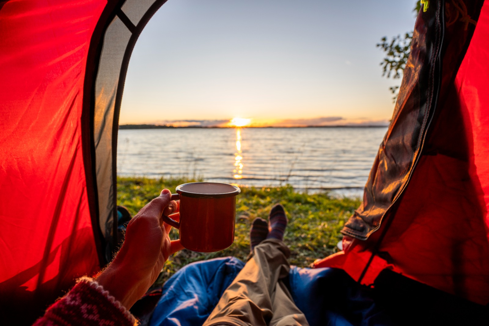 Hombre dentro de una carpa y lago a sus pies