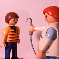 Odontóloga mostrando herramienta a niño paciente