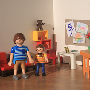 padre con niño en la sala de espera. hay asientos, juegos para niños, una cartelera con dibujos