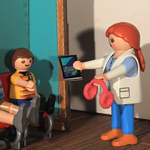 dentista entrega al niño unos auriculares y una pantalla para ver un video