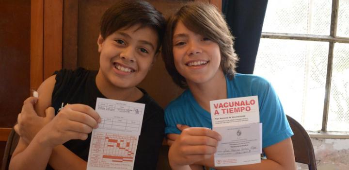 Imagen de niños mostrando el carné de vacunas Imagen de niños mostrando el carné de vacunas