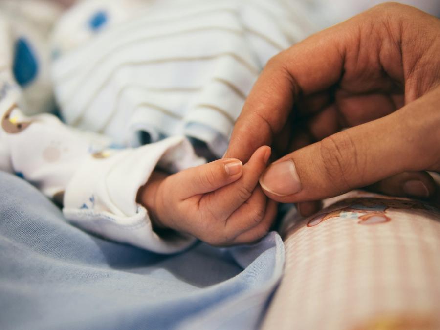 Mano de bebé recién nacido y de su madre