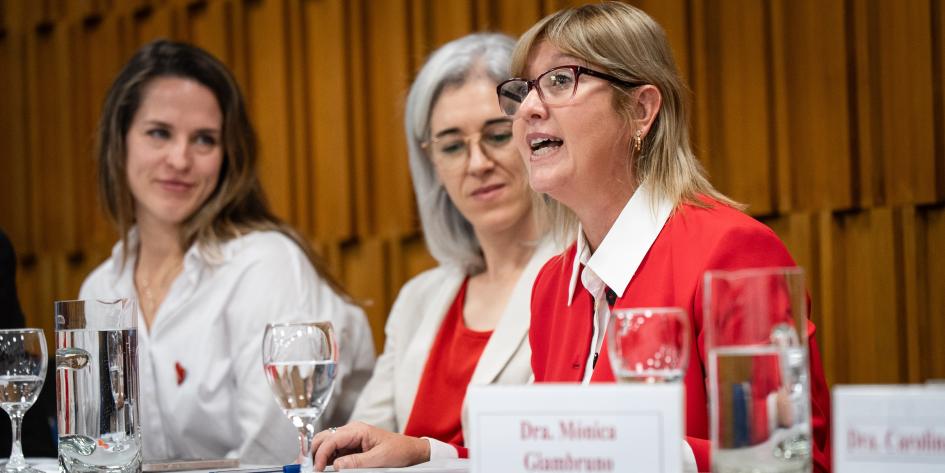 Ministra en acto por Día Nacional de Concientización de la Salud Cardiovascular de la Mujer La Ministra se dirige al público. Dos autoridades mujeres a su lado la miran con atención.