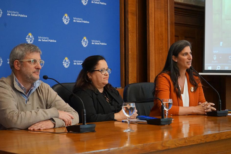Directores en presentación de la guía 3 personas en mesa de autoridades, habla al micrófono Virginia Natero