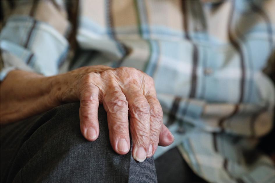 Día de la toma de conciencia contra el abuso y maltrato en la vejez Mano de una persona mayor apoyada en su rodilla