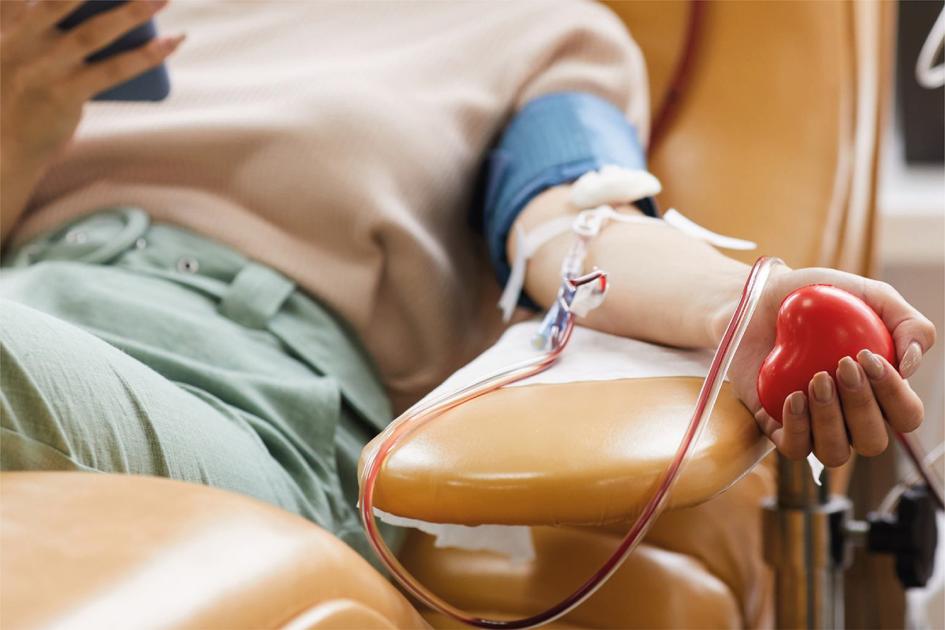 Día Mundial del Donante de Sangre Persona dona sangre sentada en un sillón, aprieta un amansalocos en su mano