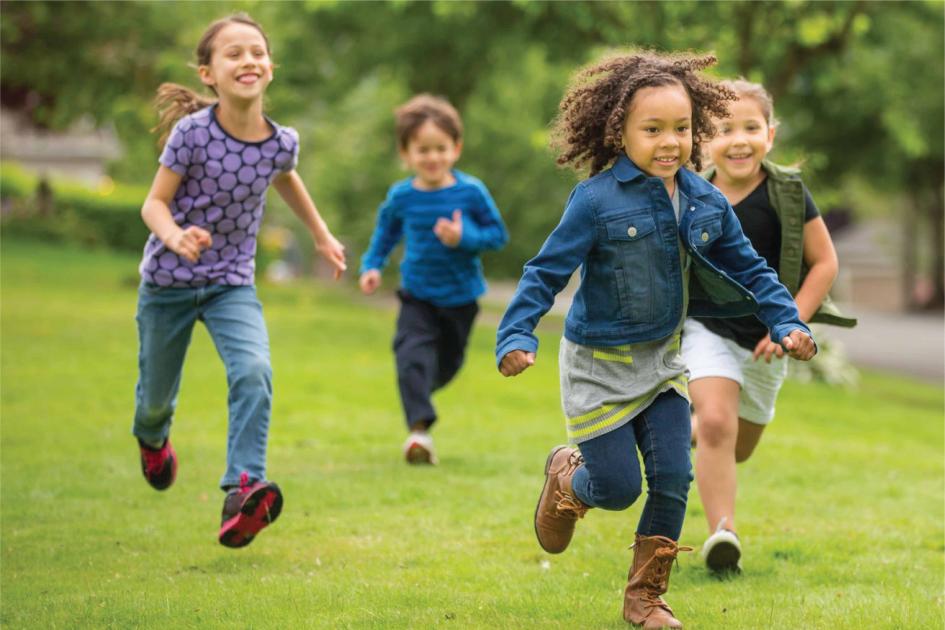 Niños corriendo Tres niñas y un niño corren alegres en un parque