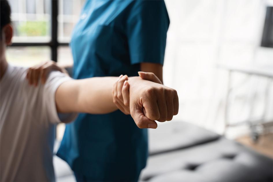 Día mundial de la rehabilitación motriz Personal de salud realiza fisioterapia en hombro y brazo de un paciente