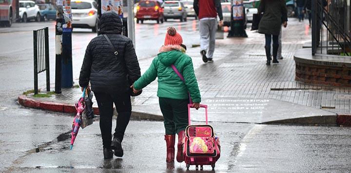 Imagen de una madre y su hija cruzando la calle