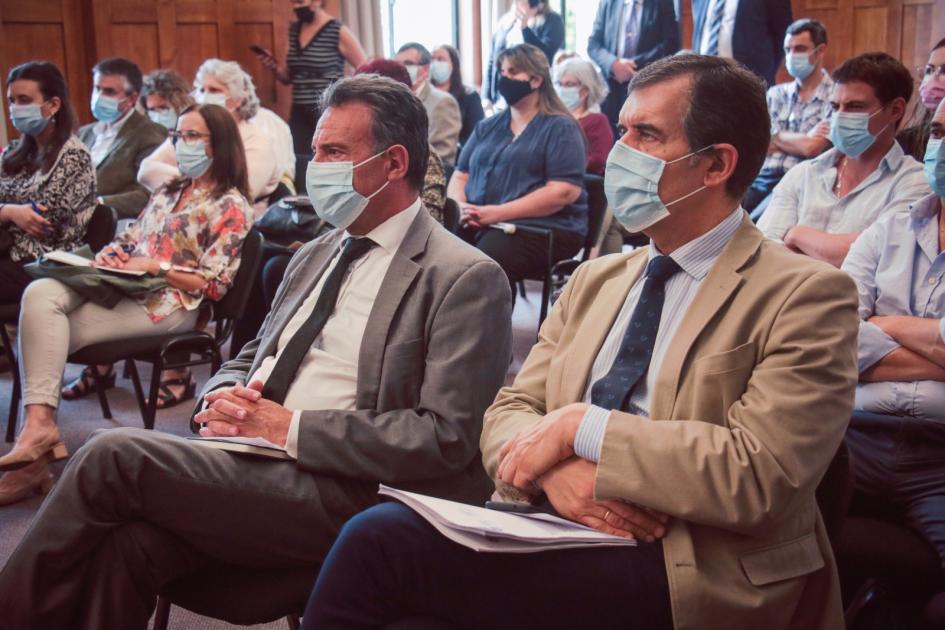 Autoridades MSP Daniel Salinas y Miguel Asqueta sentados en sección del público miran hacia fuera del cuadro