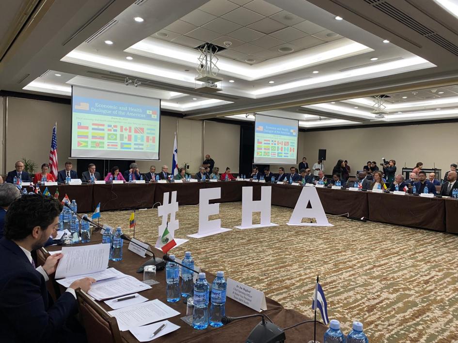 Diálogo económico y de salud de las Américas Participantes sentados al rededor de una mesa en forma de u