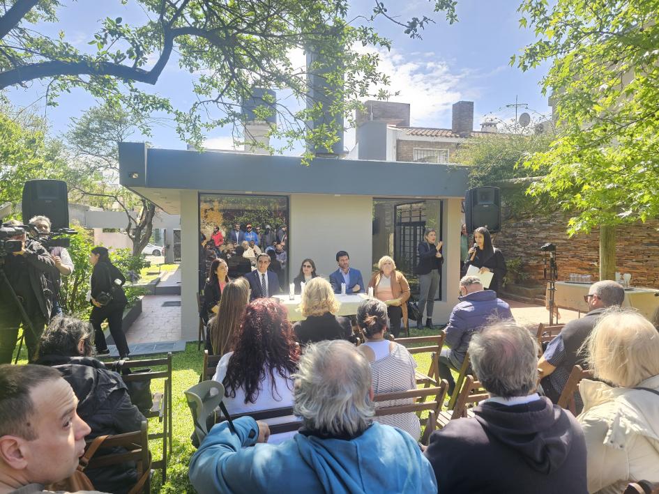 Inauguración de la Casa de Medio Camino Jacarandá En el patio se ven los asistentes de espaldas, autoridades de frente, detrás, y al fondo la casa