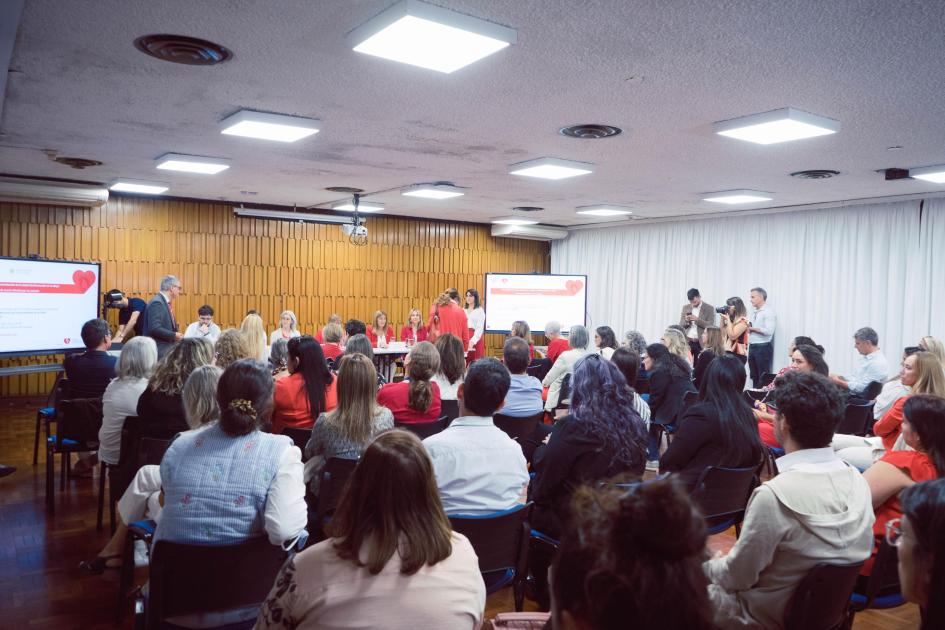 Público asistente Público de espaldas y al fondo la mesa de autoridades mujeres