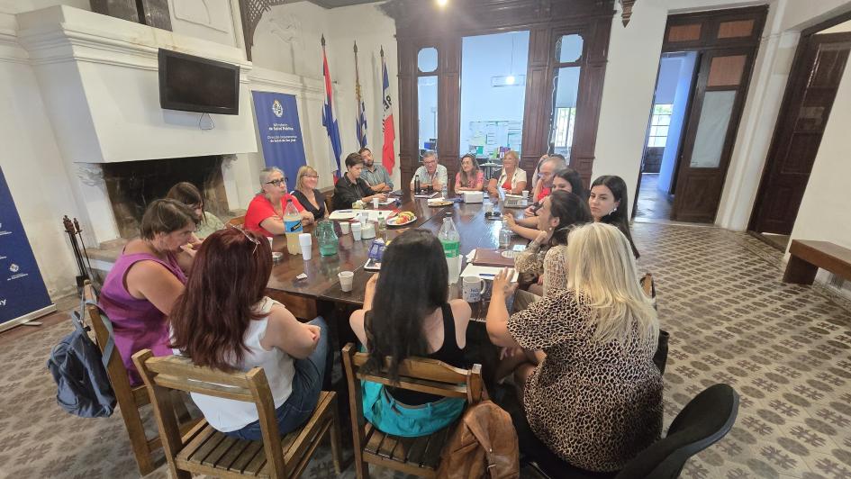 Reunión con funcionarios de DDS San José Autoridades del MSP y funcionarios de la DDS sentados al rededor de una mesa larga rectangular