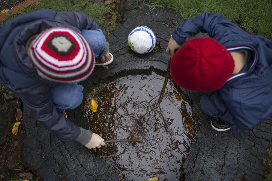Dos niños abrigados jugando al aire libre Dos niños abrigados jugando al aire libre