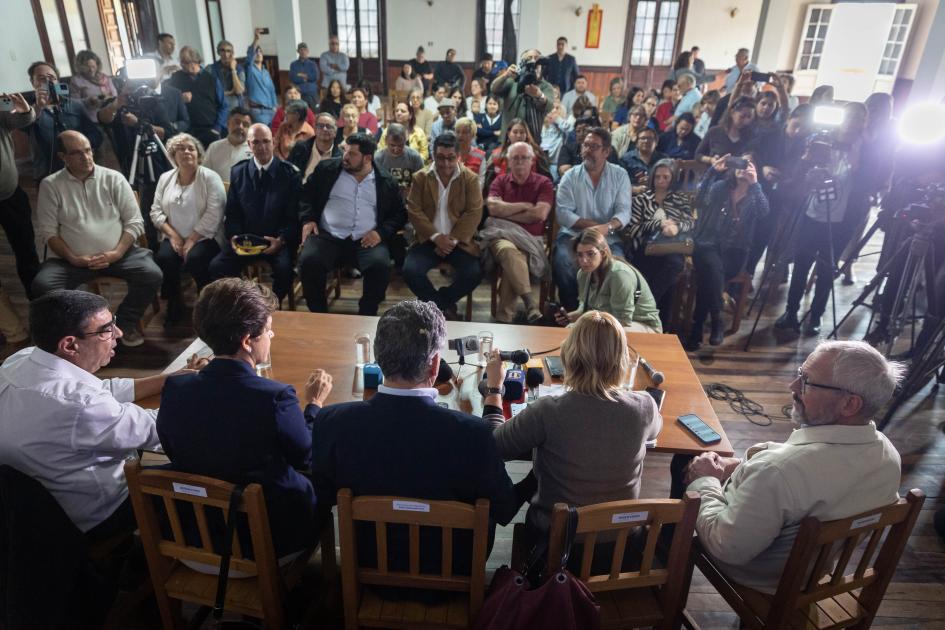 Presidente y gabinete del MSP en conferencia de prensa Toma desde arriba muestra espaldas de las autoridades y público asistente y cámaras frente a ellos