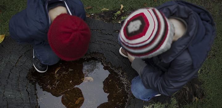 Dos niños jugando al aire libre muy abrigados