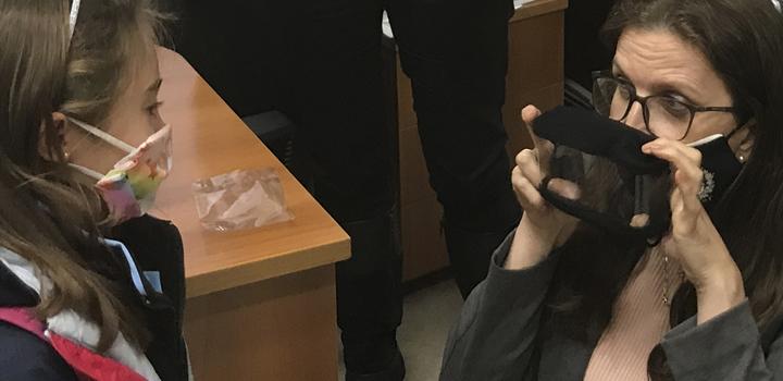 Mujer muestra tapaboca inclusivo a niña Mujer muestra tapaboca inclusivo a niña
