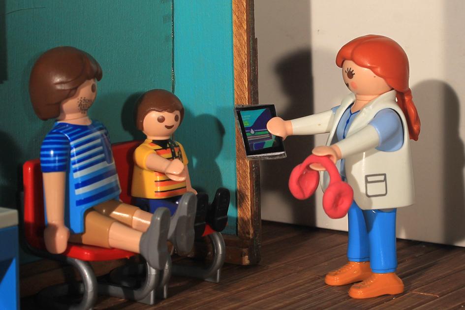 Vinculo con el paciente Odontóloga ofrece al niño paciente una tablet y unos auriculares