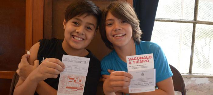 Imagen de niños mostrando el carné de vacunas Imagen de niños mostrando el carné de vacunas