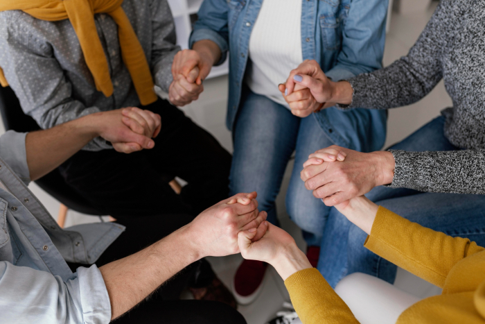 Apoyo sociocomunitario Personas de ambos sexos y edades en ronda, tomadas de la mano