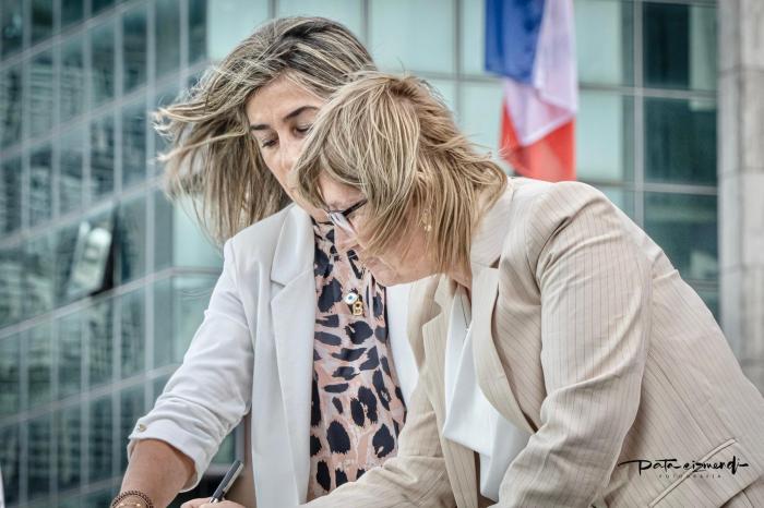 Cristina Lustemberg firma el acta, al fondo la Torre Ejecutiva