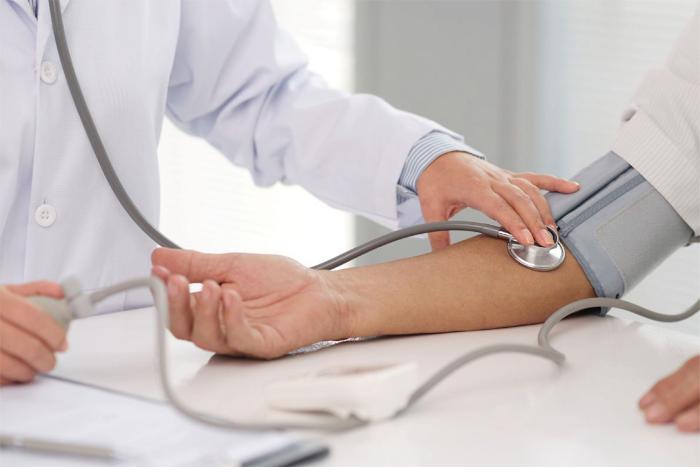 Día mundial de la hipertensión arterial Médico toma la presión arterial de un paciente