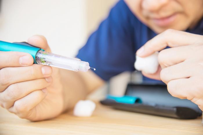 Hombre prepara insulina para inyectarse
