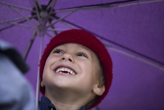 Niño sonriendo con un paraguas