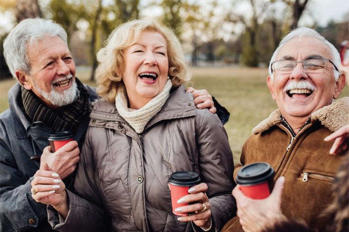 Una mujer y dos hombres mayores ríen