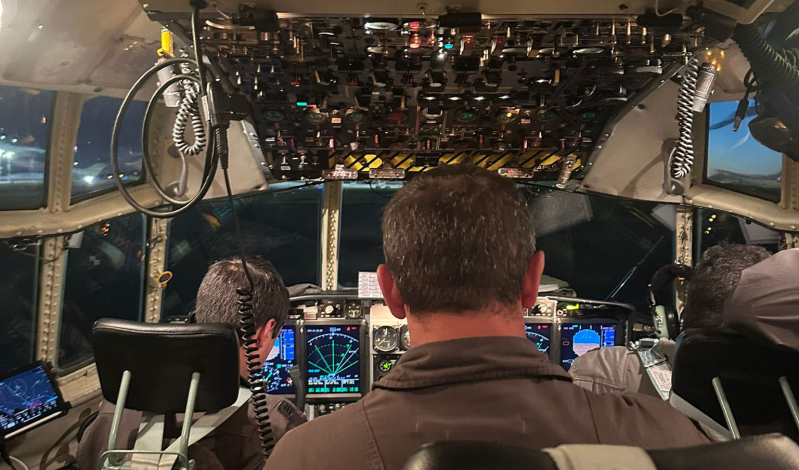 Pilotos de espaldas a cámara en cabina de un avión de la Fuerza Aérea Uruguay