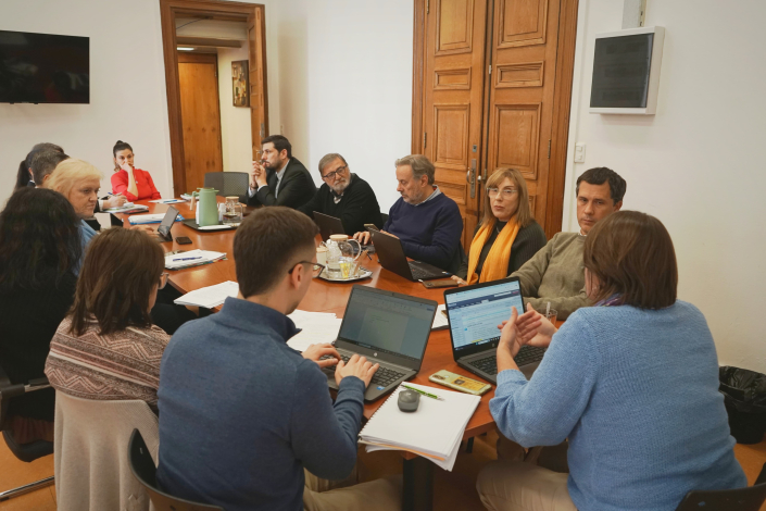 Integrantes de la JUNASA trabajan sentados al rededor de una mesa
