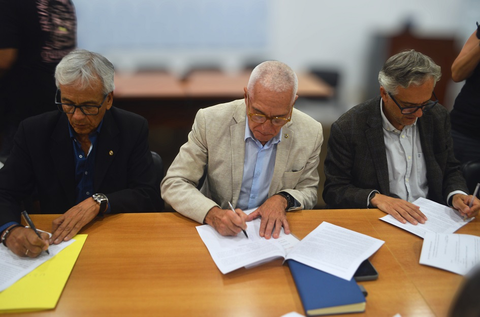 Castillo, Negro y Arim firmando el acuerdo