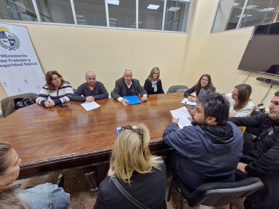 Participantes alrededor de la mesa durante la firma del acuerdo