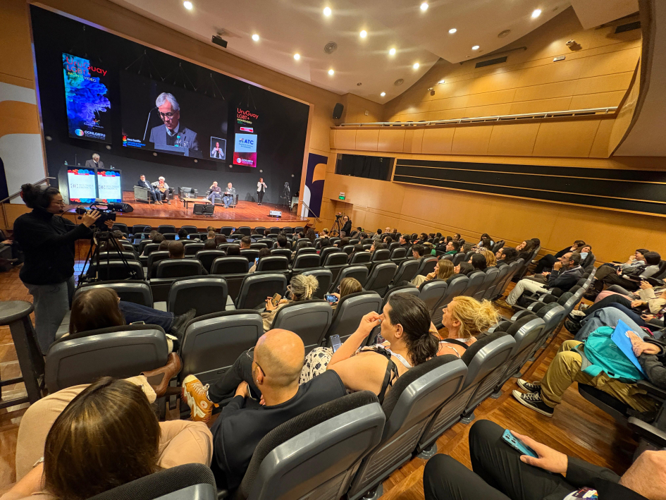 Foto desde el fondo del salón, con público y expositores
