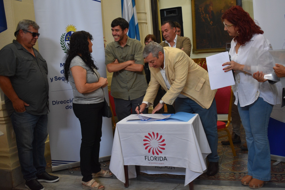 Araya, intendente firmando sobre una mesa y demás asistentes