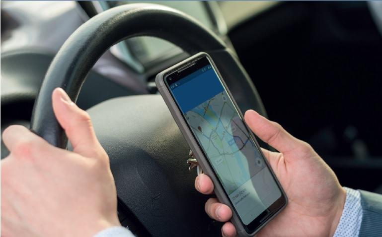 Aplicaciones de transporte Chofer con celular en mano
