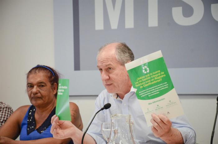 Ley Gestión de Residuos Murro sosteniendo un folleto y un adhesivo sobre la Ley de Gestión de Residuos
