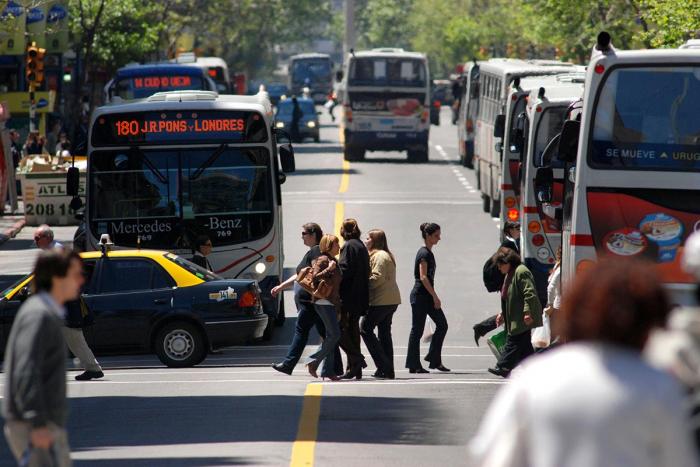 Movimiento de personas y de ómnibus en la calle 18 de julio en Montevideo