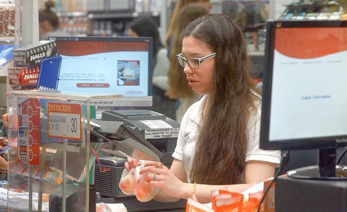 Ley de Empleo Joven trabajando como cajera en un supermercado