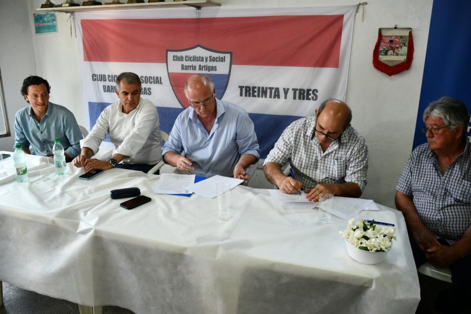 Autoridades y representantes firmando el convenio social