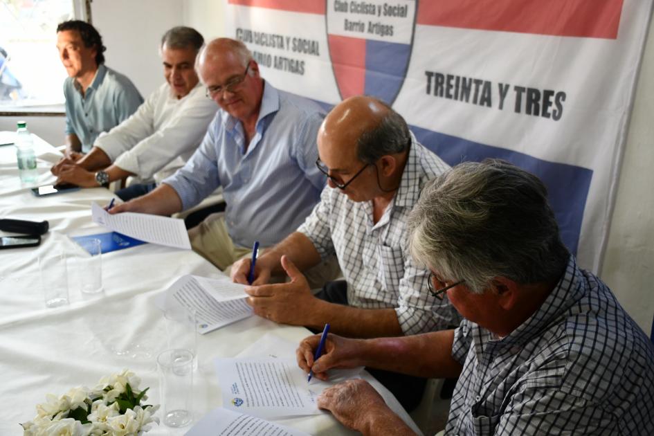 Autoridades y representantes firmando el convenio social