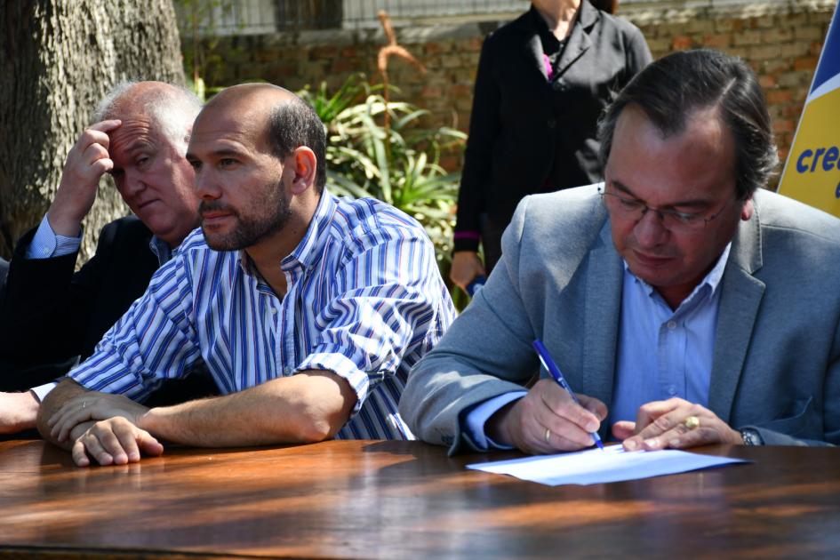 Integrantes de la mesa firmando el Convenio