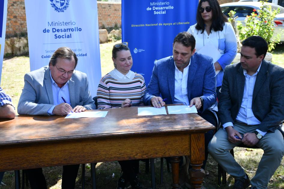 Integrantes de la mesa firmando el Convenio