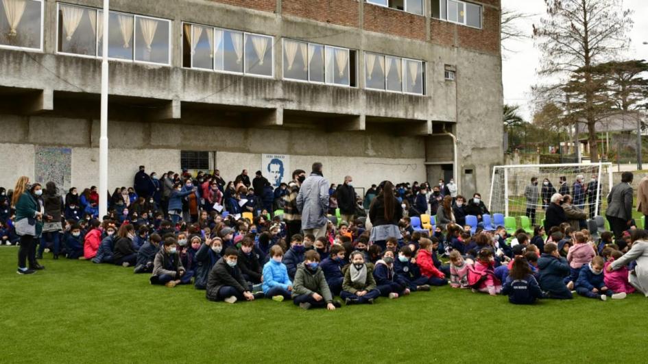 Niños del centro Don Bosco sentados en la cancha