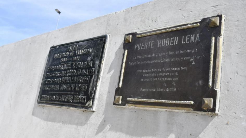 Placa en senda peatonal del puente Maestro Ruben Lena