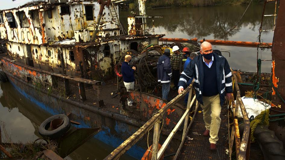 Avanza retiro de barcos abandonados en arroyo Las Vacas Ministro Olaizola camina por embarcación en proceso de desguace