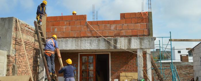 Obreros trabajando en reconstrucción de propiedades en Dolores