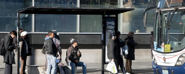 Personas en parada de ómnibus Personas en parada de ómnibus